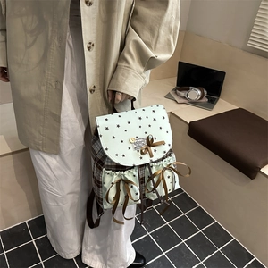 Cute star print backpack in brown plaid and green canvas with ribbon bows shown by a model