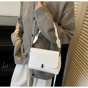 Detail of white leather shoulder bag with woven strap and silver square buckle closure