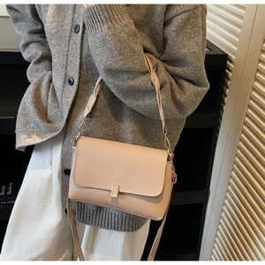 Détail d'un sac bandoulière rose avec poignée tressée et fermoir en métal doré