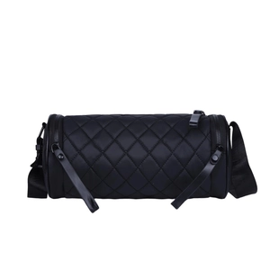 Chic black quilted cylinder crossbody bag with minimalist nylon design and woven strap