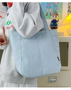 Detailaufnahme einer hellblauen tragetasche mit großer kapazität und vordertaschen am model