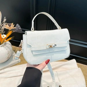 Elegant white crocodile embossed handbag with a gold twist lock clasp and adjustable strap
