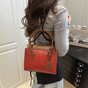 Sac à main chic rouge texture litchi avec poignées marron et logo doré tendance