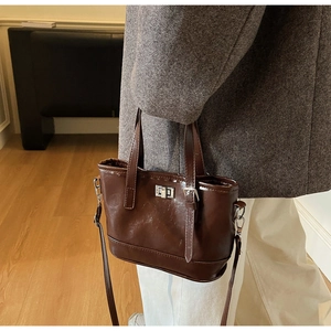 Gros plan d'un sac bandoulière marron en similicuir avec boucle sur un mannequin