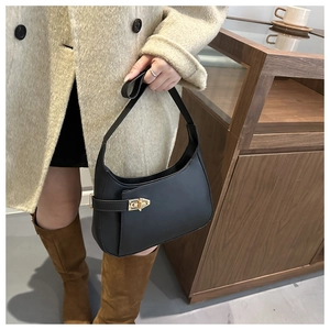 Detail of minimalist black hobo bag featuring premium texture and gold twist lock clasp