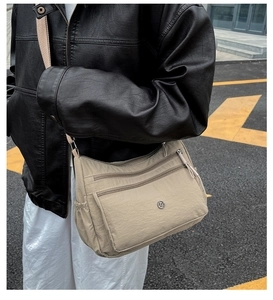 Dettaglio della borsa a tracolla in nylon kaki con tasche multiple e chiusura a coulisse