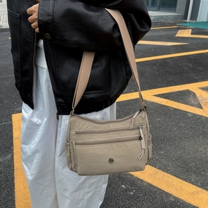 Dettaglio della borsa a tracolla in nylon kaki con tasche a cerniera e ampia tracolla