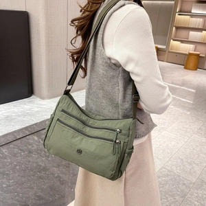 Vista dettagliata della borsa a tracolla in nylon verde salvia con design multi-vano
