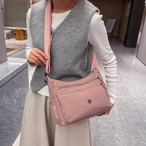 Dettaglio della borsa a tracolla rosa in nylon con tasche multiple e tracolla regolabile
