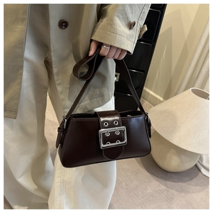 Sac sous le bras en cuir marron foncé avec boucle argentée porté par un mannequin