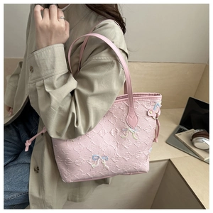 Detail of pink quilted tote bag with colorful bow embroidery and textured letters
