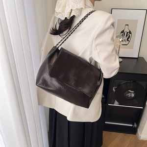 Large dark brown leather tote bag with silver chain strap for chic commuting