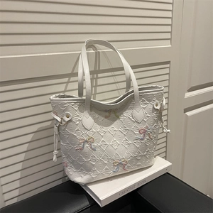 White quilted tote bag with colorful bows and drawstring detail for daily use