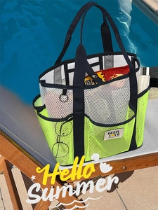 Detail of a large fluorescent yellow mesh tote bag with snacks by a summer swimming pool