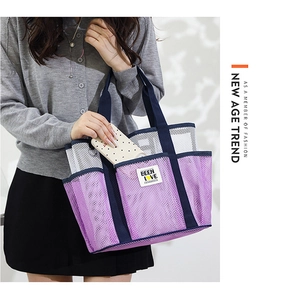 Detail view of large mesh beach tote bag with purple accents and multiple side pockets