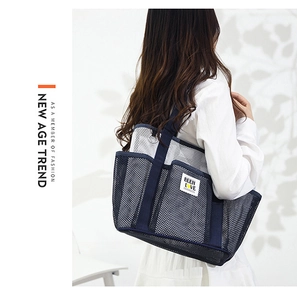 Detailed shoulder view of a large navy mesh tote bag for swimming and beach vacations