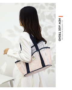 Pink mesh tote bag with blue straps and multiple pockets shown on model against white wall