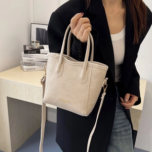 Chic beige faux leather bucket bag with top handles and adjustable strap for women