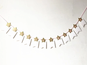 Détail de la guirlande photo avec étoiles dorées pailletées pour premier anniversaire