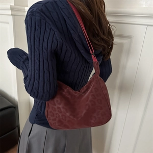 Vintage leopard print burgundy crescent shoulder bag worn by model in casual style