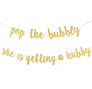 Close-up of gold glittery 'Pop the Bubbly' and 'She is getting a hubby' party banners