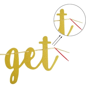 Close-up of gold glitter letter banner with plastic needle for easy DIY party assembly