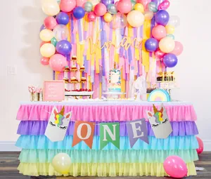 Detail of five-layer rainbow tulle table skirt with ruffle design for unicorn birthday party