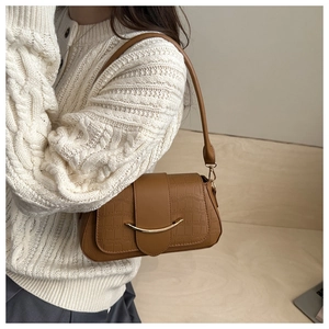 Détail du sac bandoulière en cuir gaufré crocodile caramel avec boucle en métal doré