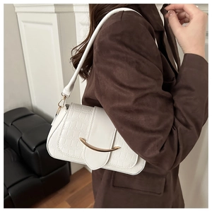 Détail du sac à bandoulière blanc à motif crocodile avec boucle en métal doré élégante