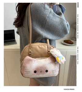 Chic cat-themed crossbody bag with plush pocket and charm worn by a model