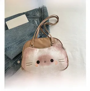 Brown leather tote with plush cat face design and top handles shown with smartphone for scale