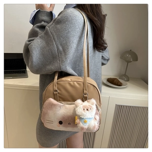 Lifestyle view of khaki cat-themed shoulder bag with plush pocket and bear charm