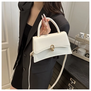 Détail du sac à main blanc élégant avec fermoir doré rond et texture en cuir synthétique
