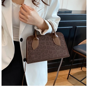 Detail of vintage leopard print handbag with brown leather handle and elegant texture