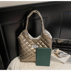 Detail of metallic quilted tote bag with Fashion Instinct label and spacious interior