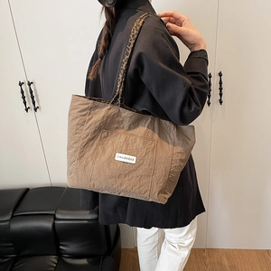 Brown nylon tote bag with leopard print straps and brand patch shown on model