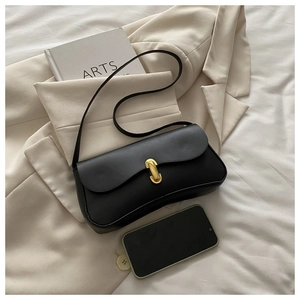 Detail of a vintage black leather underarm bag with an oval gold metal buckle