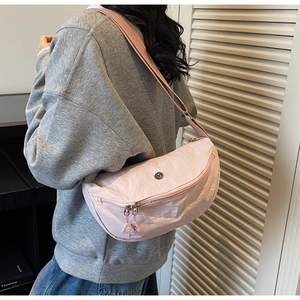 Dettaglio borsa a tracolla a mezzaluna in nylon rosa con cinturino largo e zip