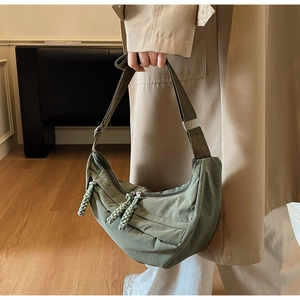 Detail of army green hobo bag featuring woven rope zipper pulls and nylon texture