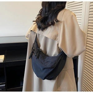 Détail d'un grand sac demi-lune en nylon noir avec cordons de fermeture éclair