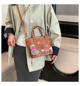 Sac fourre-tout marron chic avec imprimé ours graffiti porté par un mannequin en intérieur