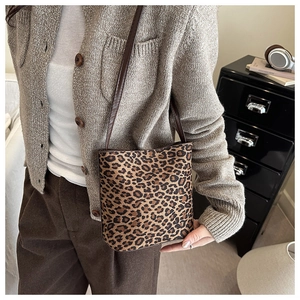 Close-up of leopard print crossbody bucket bag with slender shoulder strap detail