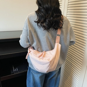 Sac bandoulière demi-lune rose avec tirettes tressées et large bandoulière