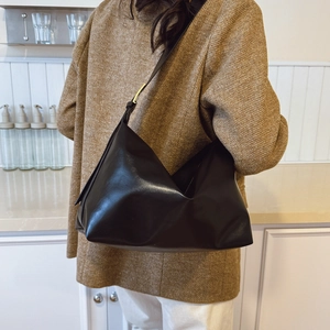 Minimalist black oversized shoulder bag in soft leather with elegant gold buckle accent