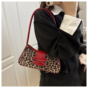 Detail der Leoparden-Schultertasche mit roter Lacklederschleife und Riemen