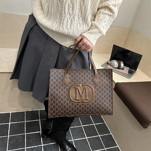 Brown tote bag with repeating M-pattern print and leather embossed M-logo for women