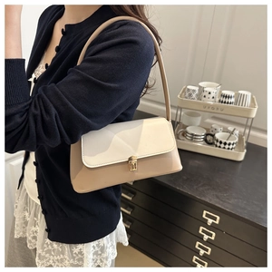Close-up of minimalist two-tone underarm bag with golden twist lock and khaki synthetic leather