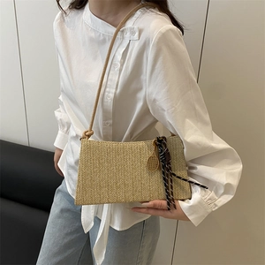 Woven straw shoulder bag with V-pattern, leather strap and gold tennis racket pendant