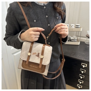 Detailed shot of canvas and brown leather crossbody bag featuring a printed cat motif