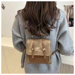 Brown canvas mini backpack with purple cat design and dual buckle flap closure details